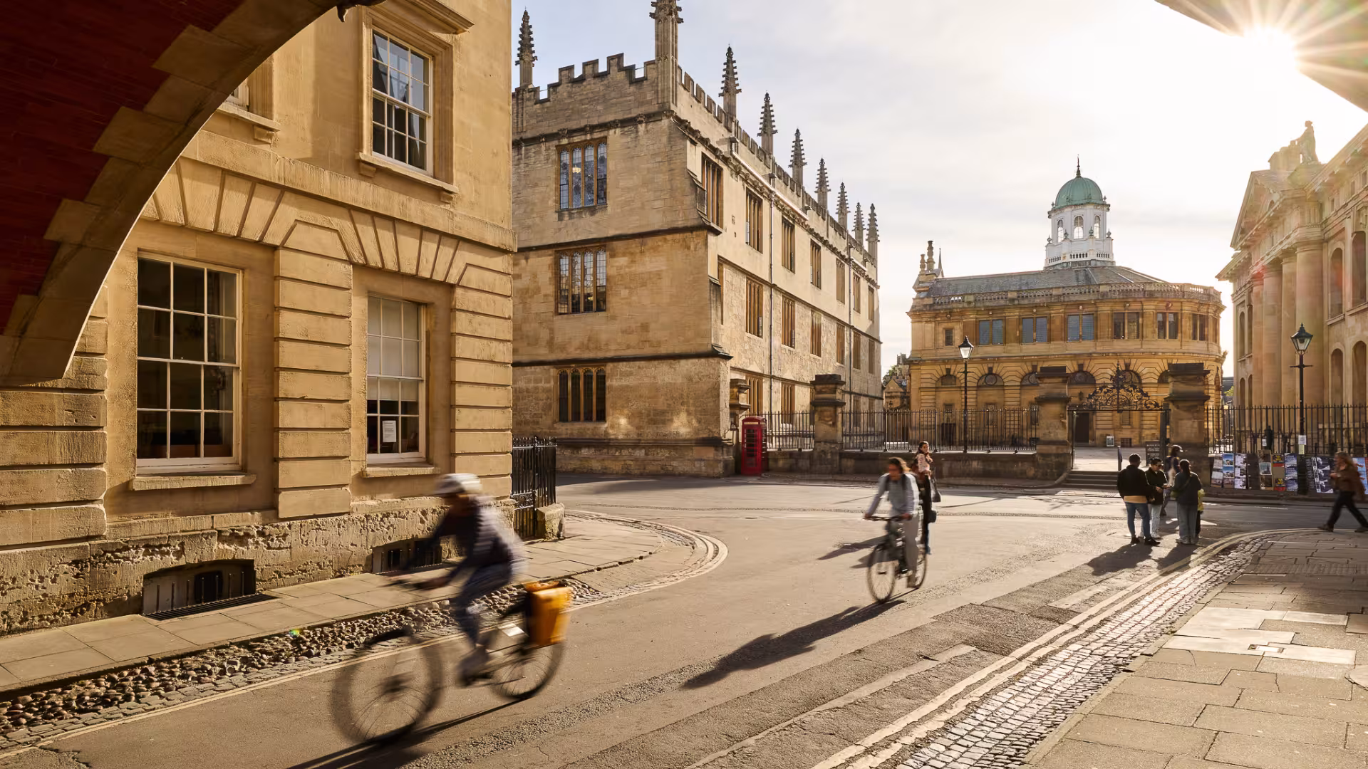 Cyclists passing beneath Hertford College's Bridge of Sighs